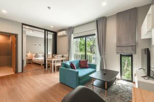 a living room with a blue couch and a table at C222 Cozy 1BR Condo with Pool Access 500 m to Beach in Rawai Beach