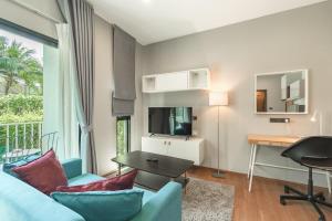 a living room with a blue couch and a table at C222 Cozy 1BR Condo with Pool Access 500 m to Beach in Rawai Beach