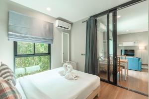 a bedroom with a white bed and a dining room at C222 Cozy 1BR Condo with Pool Access 500 m to Beach in Rawai Beach +29 photos