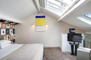 a bedroom with a bed and a flat screen tv at Hôtel A La Villa des Artistes in Paris +38 photos