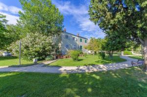 a house in a park with trees and a street at Beach & park Apartment in Kaštela