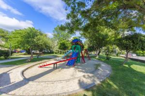 a playground with a slide in a park at Beach & park Apartment in Kaštela