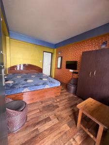 a bedroom with a large bed and a table at Swarna Kamal Homestay in Darjeeling