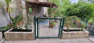ein offenes Tor mit Topfpflanzen in einem Garten in der Unterkunft A Casa dalla Ross in Marzabotto