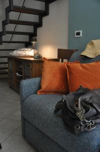 ein blaues Sofa mit orangefarbenen Kissen im Wohnzimmer in der Unterkunft A Casa dalla Ross in Marzabotto