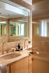 a bathroom with a sink and a large mirror at HOMY Repubblica - A Luxury Collection in Milan