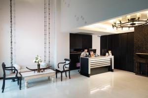 a man standing at a desk in a room at De Chai Oriental Nimman in Chiang Mai