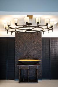 a chandelier in a room with a tub on a wall at De Chai Oriental Nimman - SHA Plus in Chiang Mai