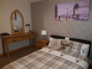 a bedroom with a bed and a table and a mirror at Lascala City Apartment in Inverness