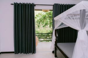 un dormitorio con una cama y una ventana en Anna Villa, en Tangalle 4 fotos más