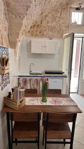 una cucina con tavolo, sedie e lavandino di Mary Home a Martina Franca