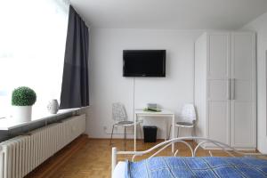 um quarto com uma cama e uma televisão na parede em Apartments Sankt Augustin em Sankt Augustin