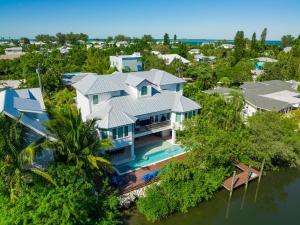 安娜玛丽亚Tern Key - New Luxury Canal Front Home with Pool Spa Dock Close to Bean Point Pine Ave的水面上房子的空中景观