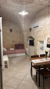un soggiorno con letto in un muro di pietra. di Mary Home a Martina Franca