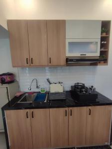 eine Küche mit Spüle und Mikrowelle in der Unterkunft Athara Villas Kav A5 Batu in Karangploso