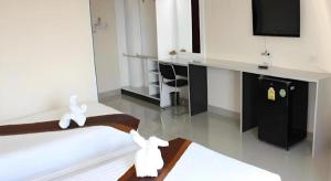 Una habitación de hotel con una cama y un televisor de pantalla plana. en The Rich Residence, en Ban Tha Kup