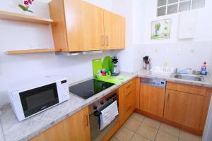 una pequeña cocina con armarios de madera y microondas en Apartments Sankt Augustin, en Sankt Augustin