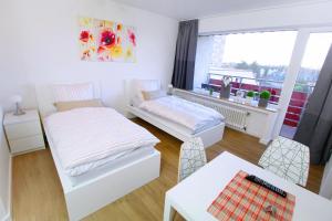 a living room with two beds and a table at Apartments Sankt Augustin in Sankt Augustin