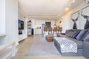 a living room with a gray couch and a living room with deer paintings at Premier Suites- Panoramic View in Cebu City