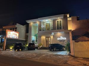 budynek z samochodami zaparkowanymi przed nim w nocy w obiekcie The Horizontal Hotel Pacitan w mieście Pacitan