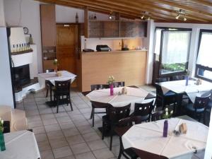 a restaurant with tables and chairs and a kitchen at Campingplatz Aichelberg in Aichelberg