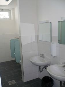 a bathroom with two sinks and a mirror at Campingplatz Aichelberg in Aichelberg +18 photos