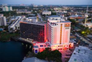een groot wit gebouw met rode lichten erop bij Ramada Plaza by Wyndham Orlando Resort & Suites Intl Drive - Newly Renovated! in Orlando