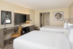 een hotelkamer met twee bedden en een televisie bij Ramada Plaza by Wyndham Orlando Resort & Suites Intl Drive - Newly Renovated! in Orlando