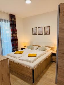 ein Schlafzimmer mit einem großen Bett mit gelben Handtüchern darauf in der Unterkunft Casa Romana 2 Siófok apartman in Siófok