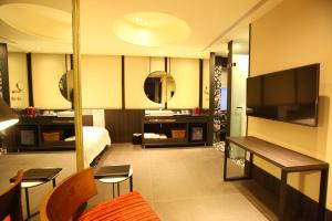 a hotel room with a bed and a television at Hotel Lainn in Kaohsiung