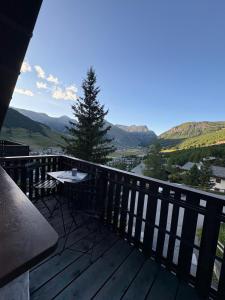 a balcony with a table and a view of the mountains at Appartamento Vistabella in Livigno