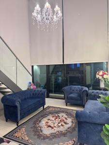 スバン・ジャヤにあるSubang Jaya One City Staycationのリビングルーム(青いソファ2台、ラグ付)