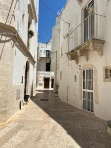 un vicolo tra due edifici bianchi con balcone di Mary Home a Martina Franca Altre 30 foto
