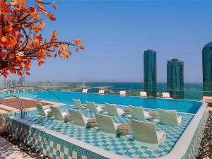 麦纳麦Conrad Bahrain Financial Harbour的一座带躺椅的游泳池位于一座建筑的顶部