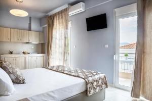 a bedroom with a bed and a large window at Troia Resort Luxury Studios in Asprovalta