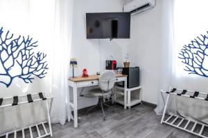 a room with a desk with a computer and chairs at Coral Rooms in Torre del Greco