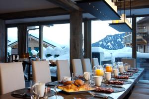 a long table with bread and orange juice on it at The Lodge in Verbier