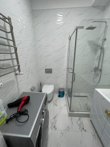 a white bathroom with a shower and a sink at ЖК Prime park in Shymkent