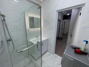 a bathroom with a glass shower and a sink at ЖК Prime park in Shymkent