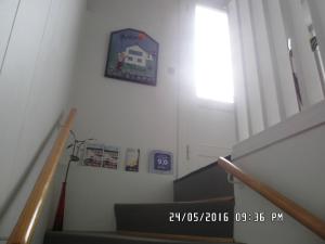 una escalera con una pared blanca con un reloj en la pared en Mit Bed & Breakfast, en Kolding