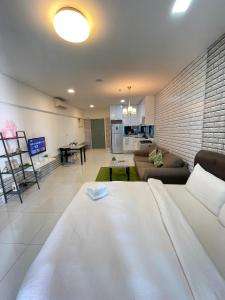 a living room with a white bed and a couch at Mercu Summer Suites Apartment With Balcony in Kuala Lumpur