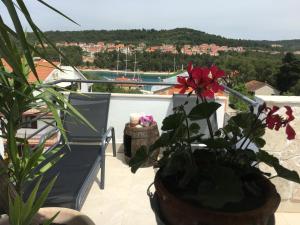 a balcony with a chair and flowers on a balcony at Anchor Apartments in Stari Grad