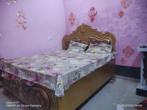 a bedroom with a bed with a floral bedspread at Rajiv Homestay in Kālīnagar