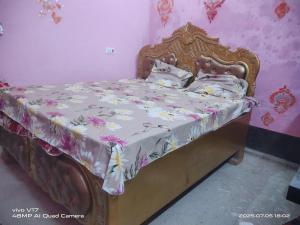 a bedroom with a bed with a floral bedspread at Rajiv Homestay in Kālīnagar