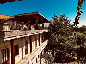 a building with a balcony with people on it at Anatolia Raymonde Cave House in Uçhisar