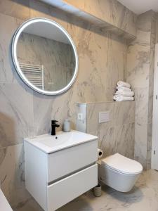 a bathroom with a white sink and a mirror at Modern Spacious Mountain View Apt in Braşov +13 photos