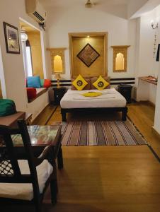 a bedroom with a bed with yellow pillows on it at Hotel Tharventure in Jaisalmer