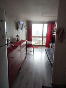 ein Zimmer mit einer Küche mit einem großen Fenster in der Unterkunft Appartement a la Montagne in Villarembert