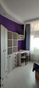 a room with a table and a purple wall at уют in Dobrovelychkivka +5 photos