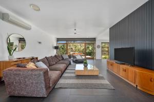 un soggiorno con divano e TV a schermo piatto di Huon Valley House a Ranelagh